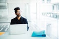 Indian Business man sitting at his desk with a laptop in office