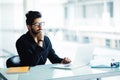 Indian business Man using laptop with hands hand on chin in his modern office Royalty Free Stock Photo