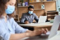 Indian business man wearing face mask working on laptop in office coworking. Royalty Free Stock Photo