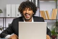 Office businessman hiding behind laptop computer making funny silly face fooling around, disrespect Royalty Free Stock Photo