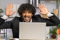 Office businessman hiding behind laptop computer making funny silly face fooling around, disrespect Royalty Free Stock Photo