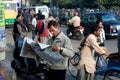 Indian businessman reads a newspaper in the crowd