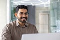 Indian businessman working happily on laptop in office Royalty Free Stock Photo