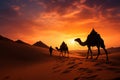 Indian cameleer with camel silhouettes in the desert at sunset