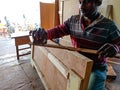 an indian carpenter applying liquid on wooden sticks during work at workshop in india January 2020