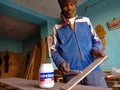 an indian carpenter applying wooden fixing liquid on plywood during work in India January 2020