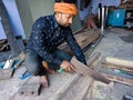 an indian carpenter chopping wood logs at workshop in India dec 2019 Royalty Free Stock Photo