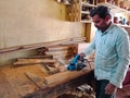 indian carpenter chopping wooden art object at factory in India 2020