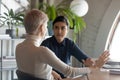 Indian and caucasian businesswomen negotiating sit at desk in office