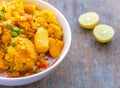 Indian Cauliflower Curry with Green Peas and Lemon Wedges