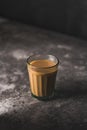 Indian chai in glass cups with metal kettle and other masalas to make the tea.