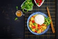 Indian chicken curry with basmati rice in blue bowl. Traditional Indian dish.