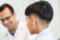 Indian child choosing eyeglasses in optics store, Boy doing eye test checking examination with optometrist in optical shop, Royalty Free Stock Photo