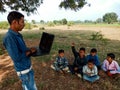 indian city boy giving laptop training to the village childrens at natural background in india January 2020 Royalty Free Stock Photo