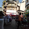 Indian city market squere with lot of people and stol and whical