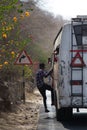 Indian conductor hangs on the bus step, according to tradition