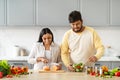 Indian Couple Cooking Food And Smiling Preparing Salad For Dinner Royalty Free Stock Photo