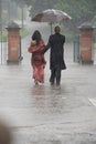 Indian couple holding an umbrella in the rain. Royalty Free Stock Photo