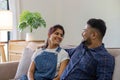 Indian couple relaxing together on sofa in living room at home, watching TV show and having happy time. Royalty Free Stock Photo