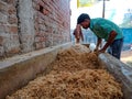 an indian cowherd boy making agricultural animals nutrition food at stable house in India January 2020