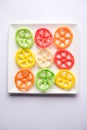 Indian crunchy fryums or papad snack in wheel, square and triangle shapewheel shape colourful fryums papad snack. selective focus