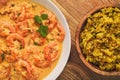 Indian cuisine - shrimps in ginger sauce and rice with curry and green pea. Royalty Free Stock Photo