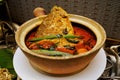 Indian Curry Fish Head with Tomato, Ladies Fingers and Curry Leaves in a Claypot