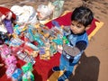 an indian cute little boy picking toys from street shop during fair program in India January 2020 Royalty Free Stock Photo