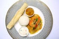 An Indian dinner ready to serve with chicken tikka masala, rice, chutney, raita, and a chapati bread.