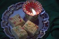 Indian Diwali sweet barfi with a burning lamp Royalty Free Stock Photo