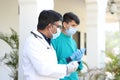 Indian doctor and his assistant with medical uniform and masks talking to their patients Royalty Free Stock Photo