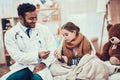 Indian doctor seeing patients at home. Doctor is taking temperature of little girl with cold. Royalty Free Stock Photo