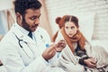 Indian doctor seeing patients at home. Doctor is taking temperature of little girl with cold. Royalty Free Stock Photo