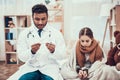 Indian doctor seeing patients at home. Doctor is taking temperature of little girl with cold. Royalty Free Stock Photo