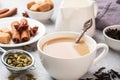 Indian drink masala tea with milk and spices. Cardamom sticks cinnamon star anise cane sugar