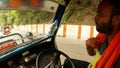 Indian driver drives auto rickshaw wipes with scarf face from sweat