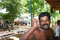 Indian drunk truck driver talking on his mobile phone on the roadside of highways in Kerala with his truck.