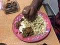 An Indian eating rice with whole green gram on a rose color plate and he is eating by his bare hands which is hygienic or