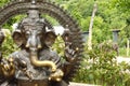 Indian elephant behind statue of Ganesha