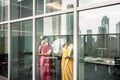 Indian employees sticking reminders on glass wall in the office