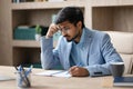 Indian entrepreneur man taking notes with concerned expression in office Royalty Free Stock Photo