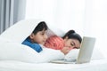 Indian family, brother and sister with traditional clothes, boy using laptop while sister sleeping, two children lying on bed Royalty Free Stock Photo