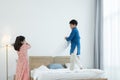 Indian family, brother and sister with traditional clothes having fun playing pillow fight, two children standing on bed and floor Royalty Free Stock Photo