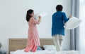 Indian family, brother and sister with traditional clothes having fun playing pillow fight, two children standing on bed together Royalty Free Stock Photo