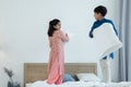 Indian family, brother and sister with traditional clothes having fun playing pillow fight, two children standing on bed together Royalty Free Stock Photo