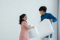 Indian family, brother and sister with traditional clothes having fun playing pillow fight, two children standing on bed together Royalty Free Stock Photo