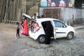 Indian family people mother father child keeping and pick up object to inside eco car at beside road in New Delhi, India