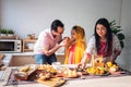 Indian family standing in the kitchen They are eating and preparing many foods on the table