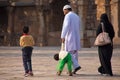 Indian family walking through courtyard of Quwwat-Ul-Islam mosque, Qutub Minar, Delhi, India Royalty Free Stock Photo