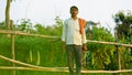 Indian farmer holding grass cutter in his bitter gourd field